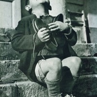 Image is from Life Magazine, 1946: It is a photo of an orphan with his first pair of new shoes.